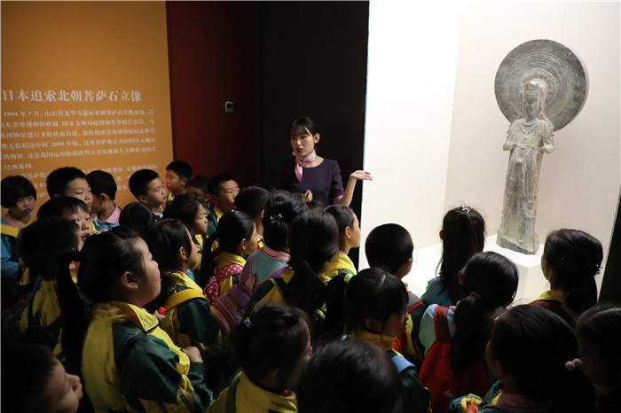 北京一小学孩子们正在津津有味听讲菩萨像的“回归之路”.jpg